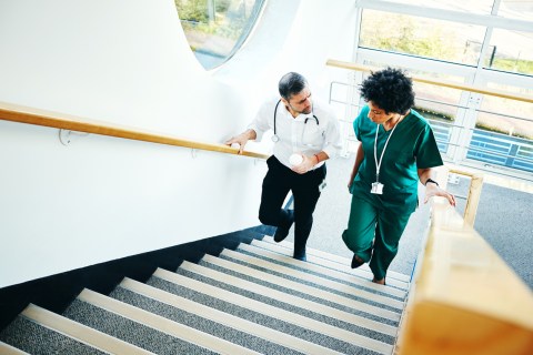 Two healthcare professionals walking up the stairs and talking