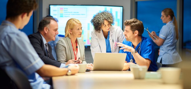 group of doctors having meeting in board room